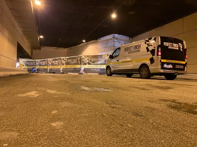 Bestelwagens van Asbestverwijdering.be bij een afgeschermde werf