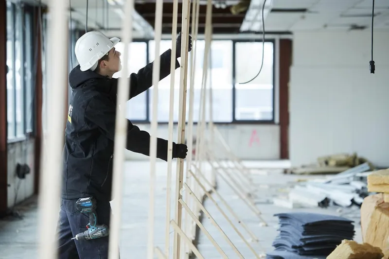 Asbestverwijderaar bouwt het houten skelet van een hermetische zone op