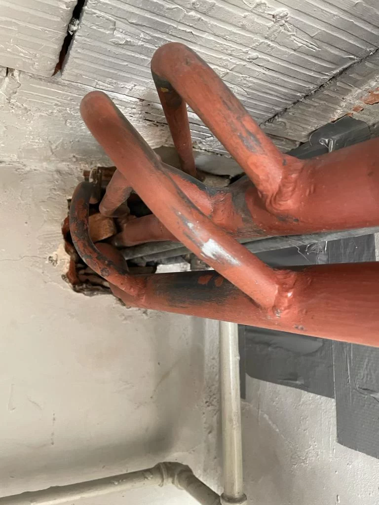 Leidingen met asbesthoudende isolatie in een kelder in Kortrijk